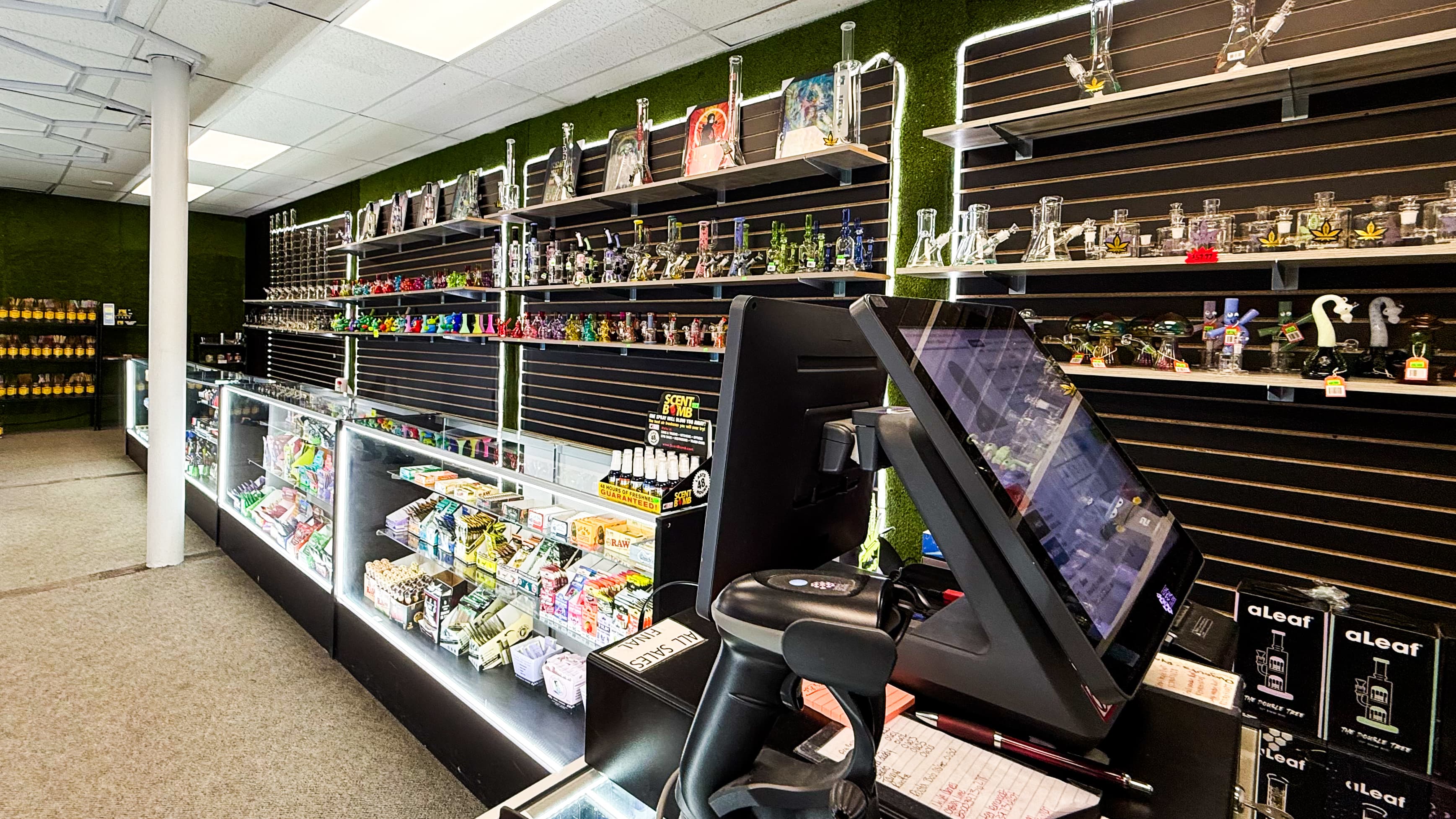 Smoke shop interior featuring shelves of glass bongs and display cases filled with smoking accessories.